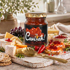 Jar of Cavi-ah! jalapeño pearls surrounded by cheese, crackers, grapes and garnished bread