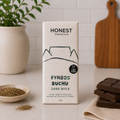Honest Chocolate Fynbos Buchu dark mylk chocolate bar with stacked chocolate pieces and dried herbs