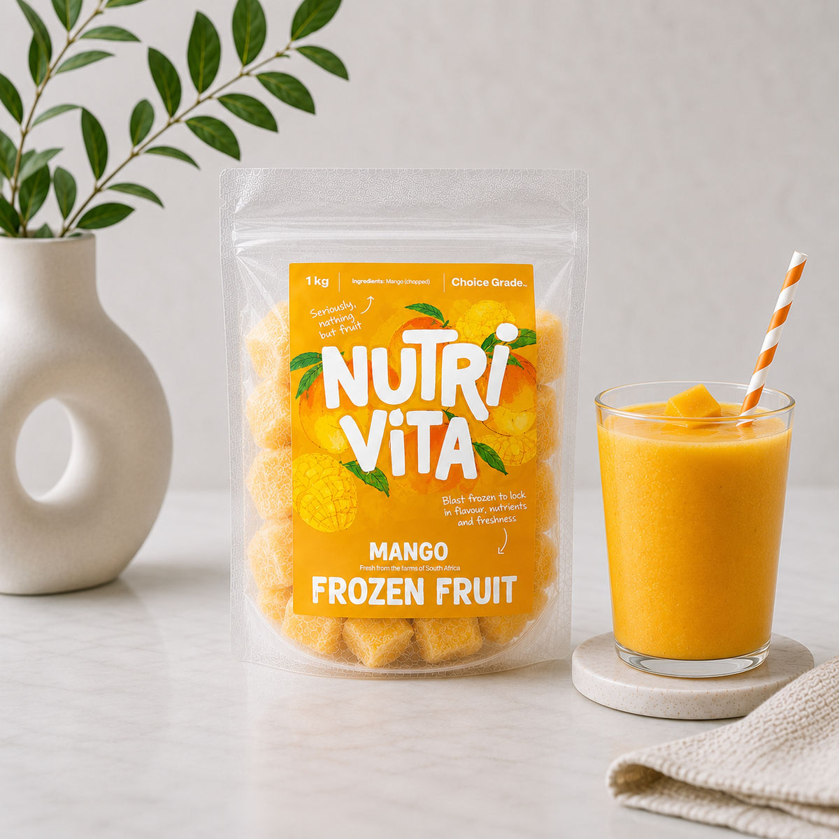 Bag of Nutri Vita frozen mango chunks beside a glass of mango smoothie with a striped straw