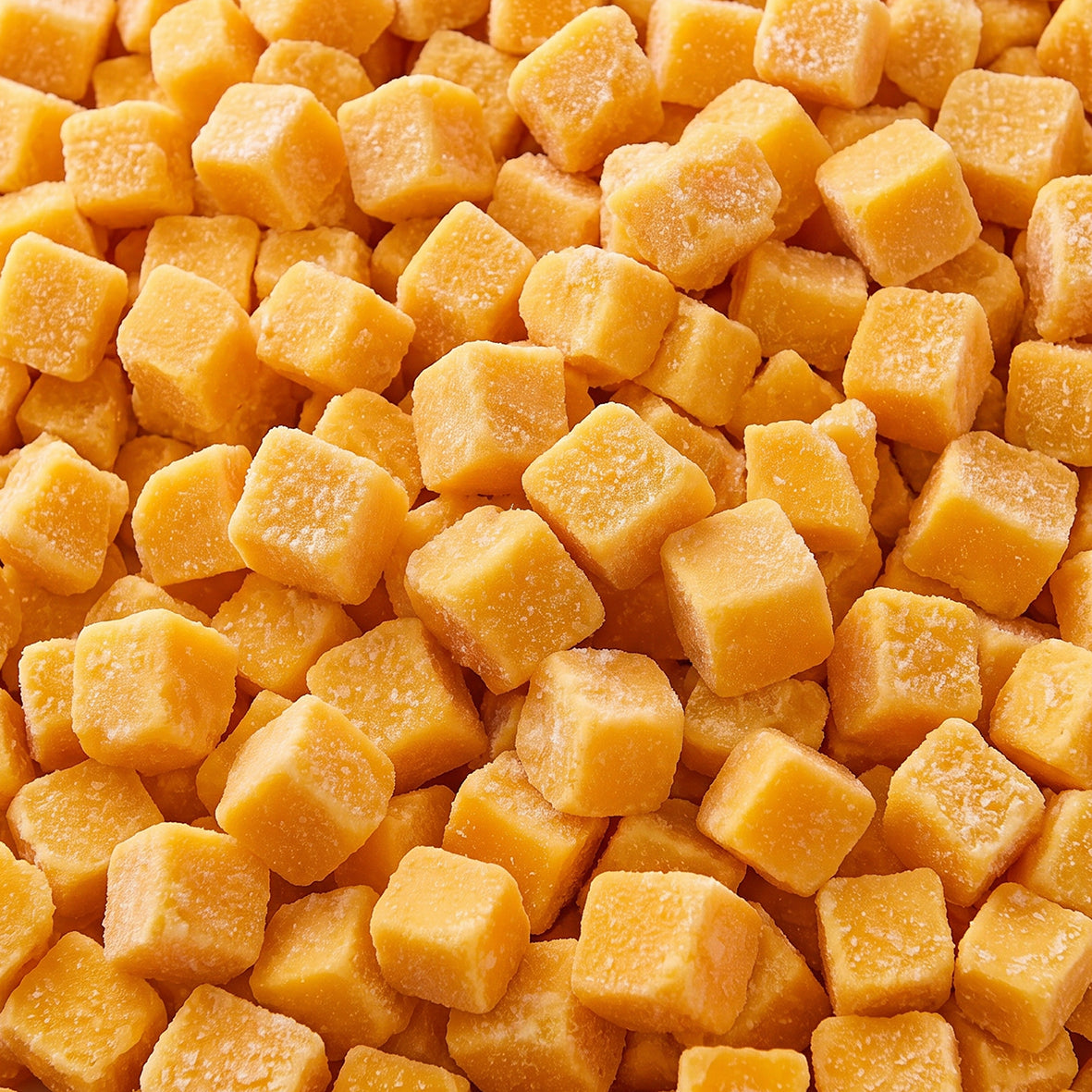 Close-up of orange frozen mango chunks covered with frost