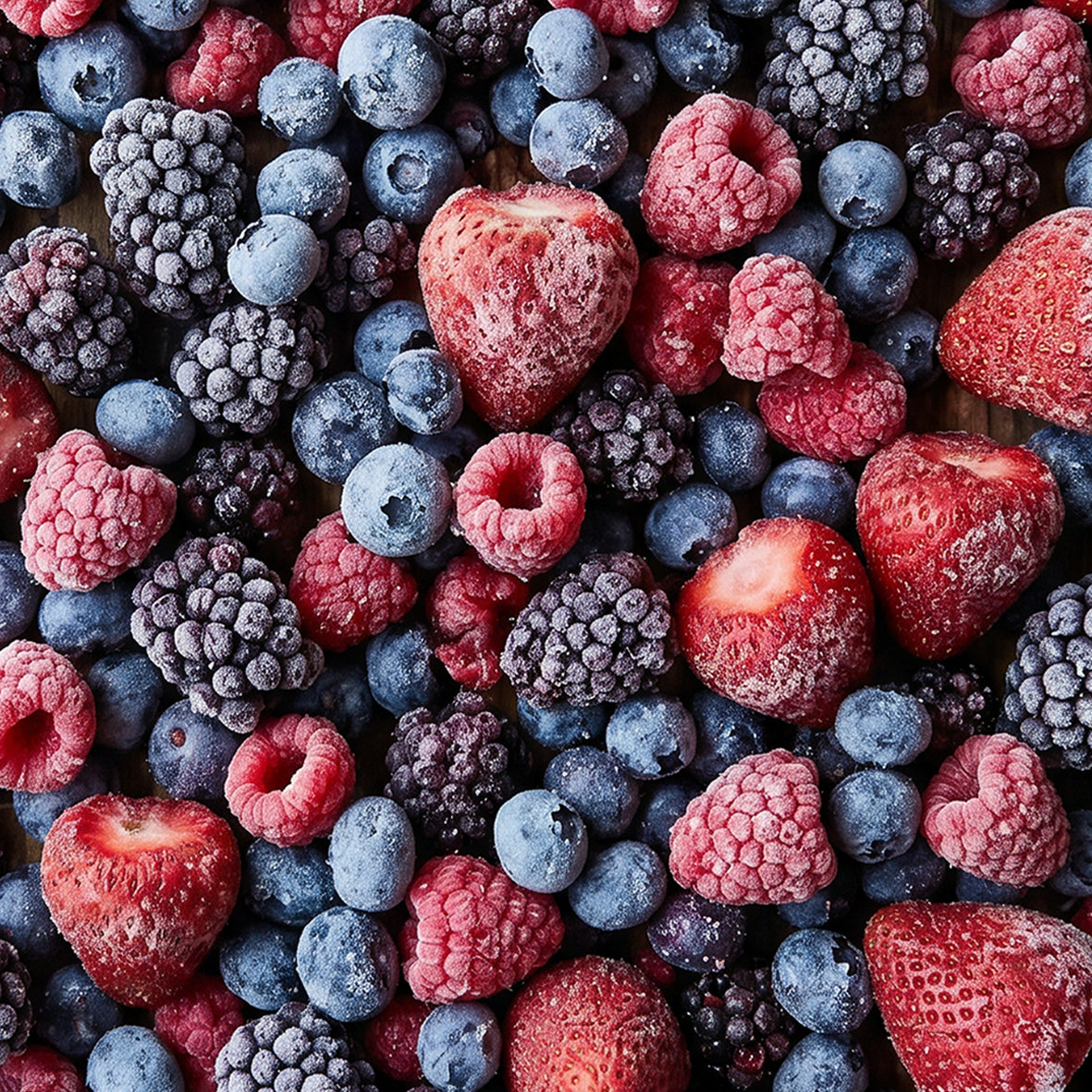 Close-up of frozen strawberries, raspberries, blueberries and blackberries coated with frost