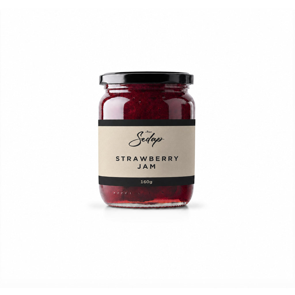 Glass jar of red strawberry jam with a black lid and cream label, front view